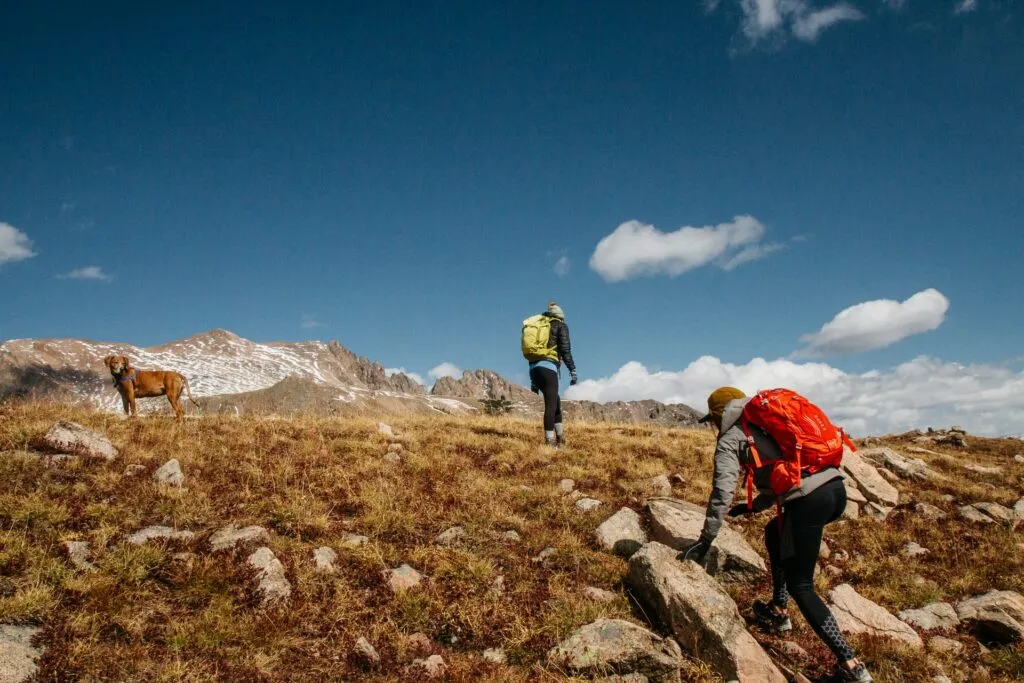 Två vandrare som klättrar i berg