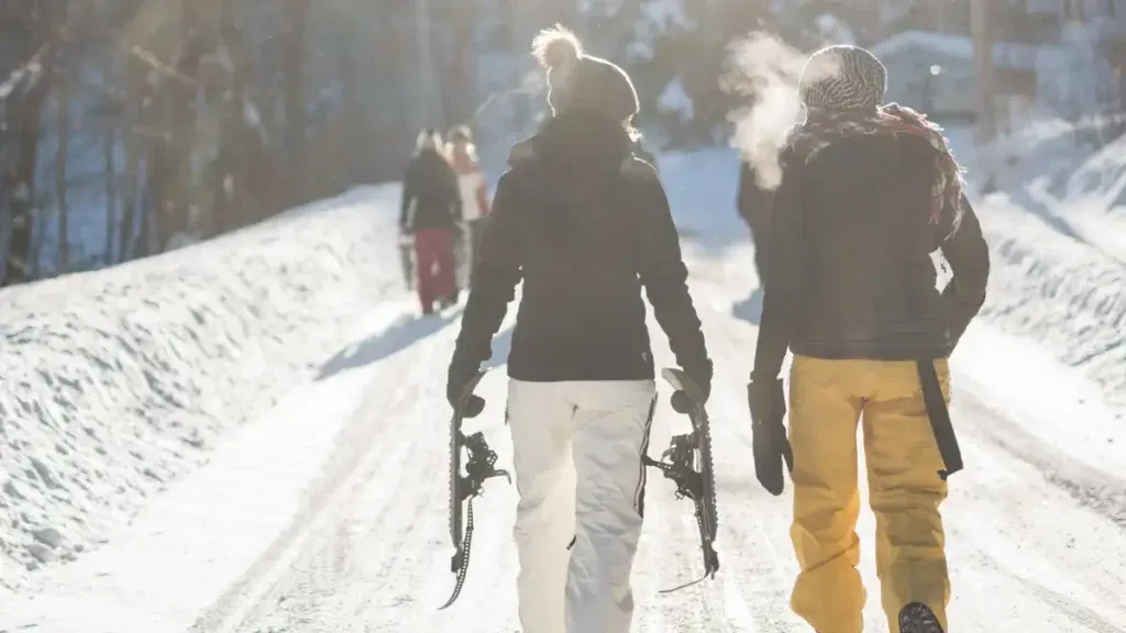 Två kvinnor i skidbyxor och skidjackor