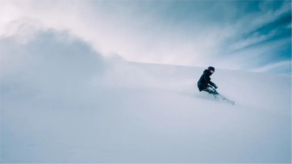 man som åker skidor i pudersnö