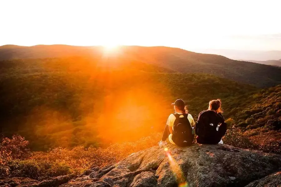 Två tjejer som sitter på ett berg